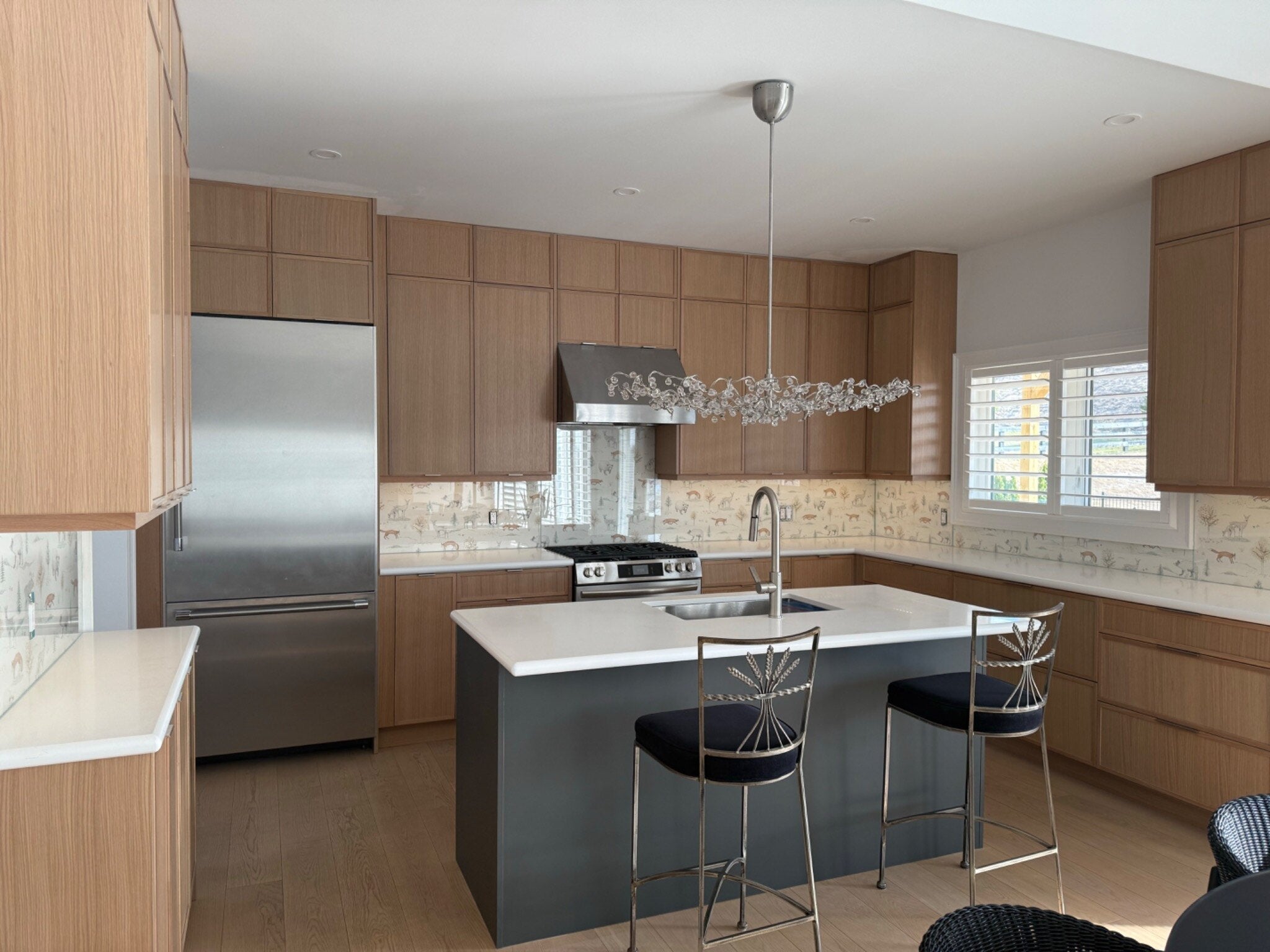 Warm wood kitchen with white island, integrated storage and statement lighting