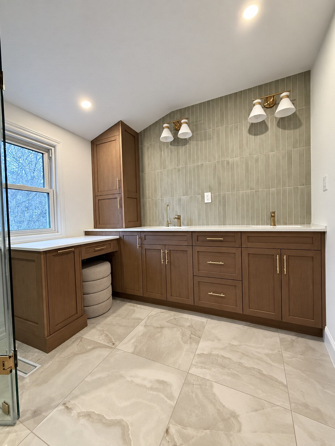 Custom red oak bathroom cabinetry with brass hardware, quartz countertop and full-height green tile