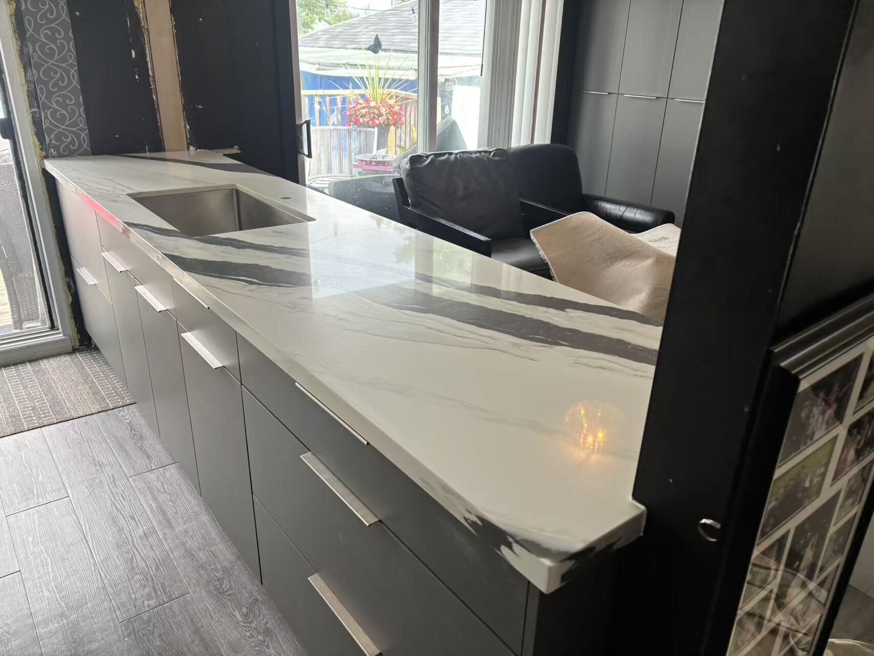 Long kitchen countertop with bold grey veining and an undermount sink